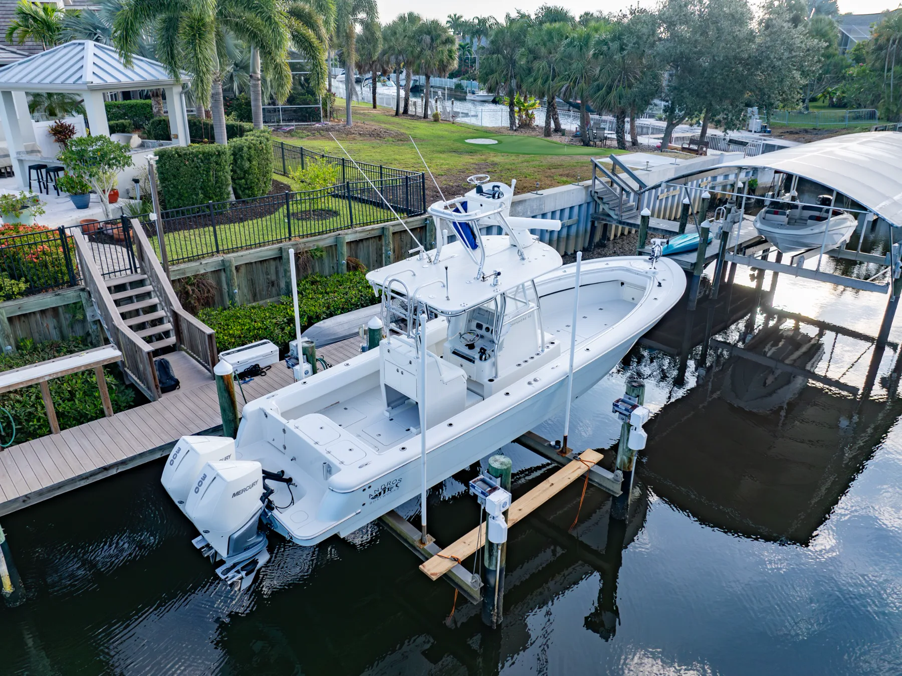 Full white center-console boat presented at a waterfront dock